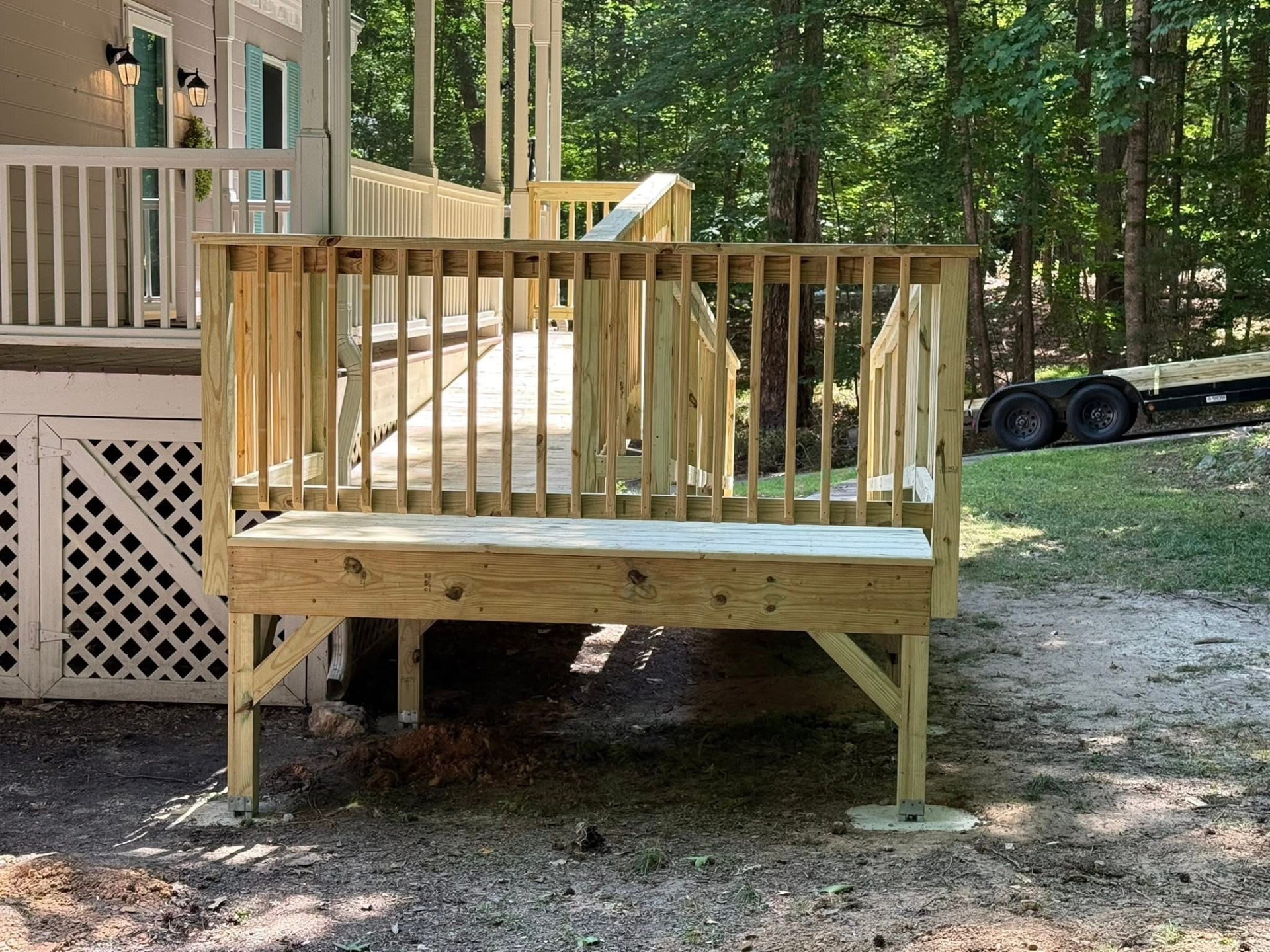 Pressure-treated wooden ramp with railings leading to a porch