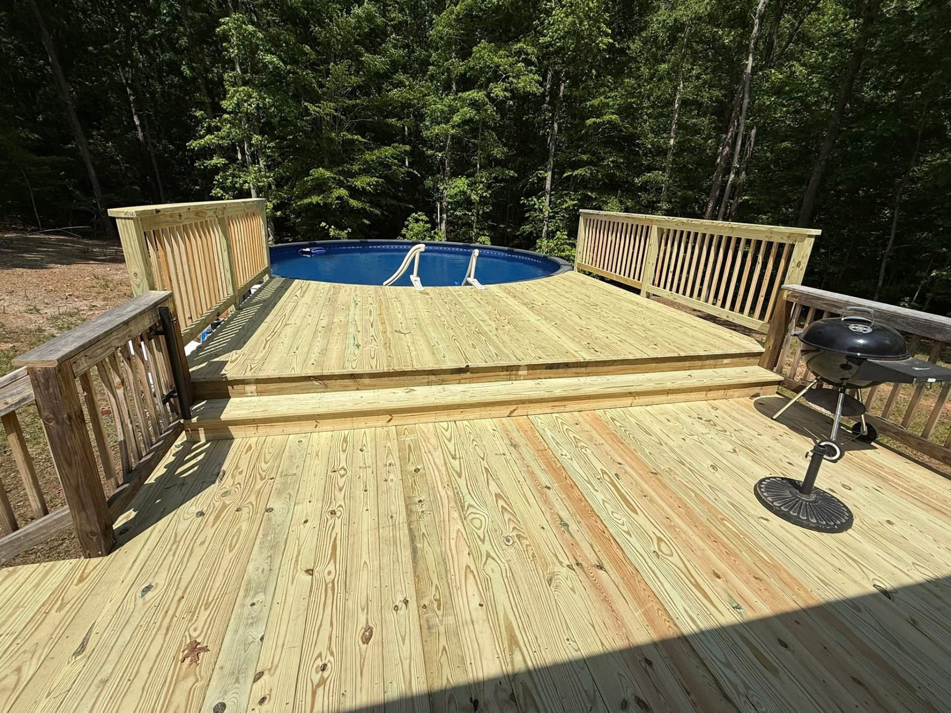 Multi-level pressure-treated pool deck with railings and steps