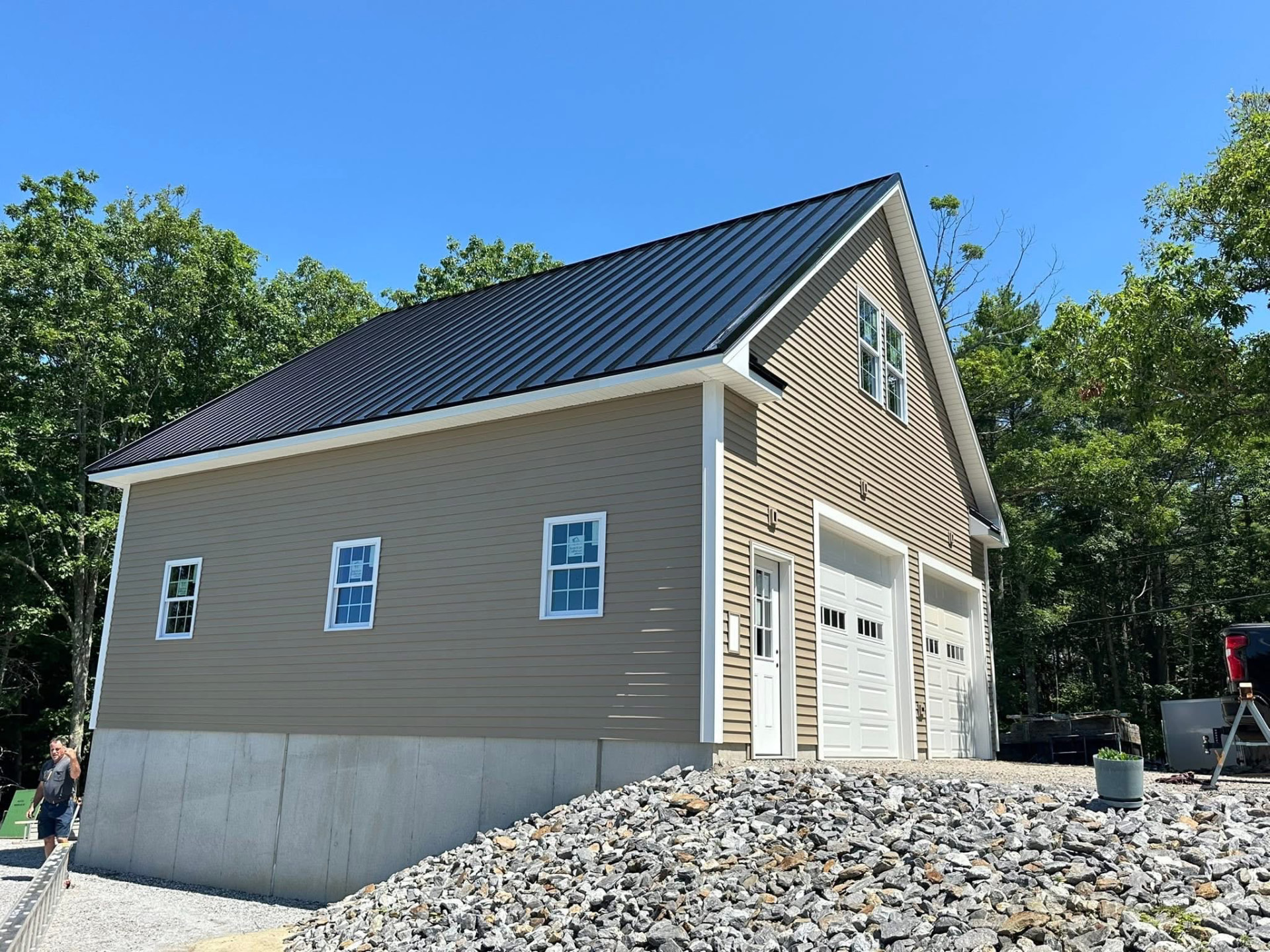 Finished garage exterior with vinyl siding and white garage doors
