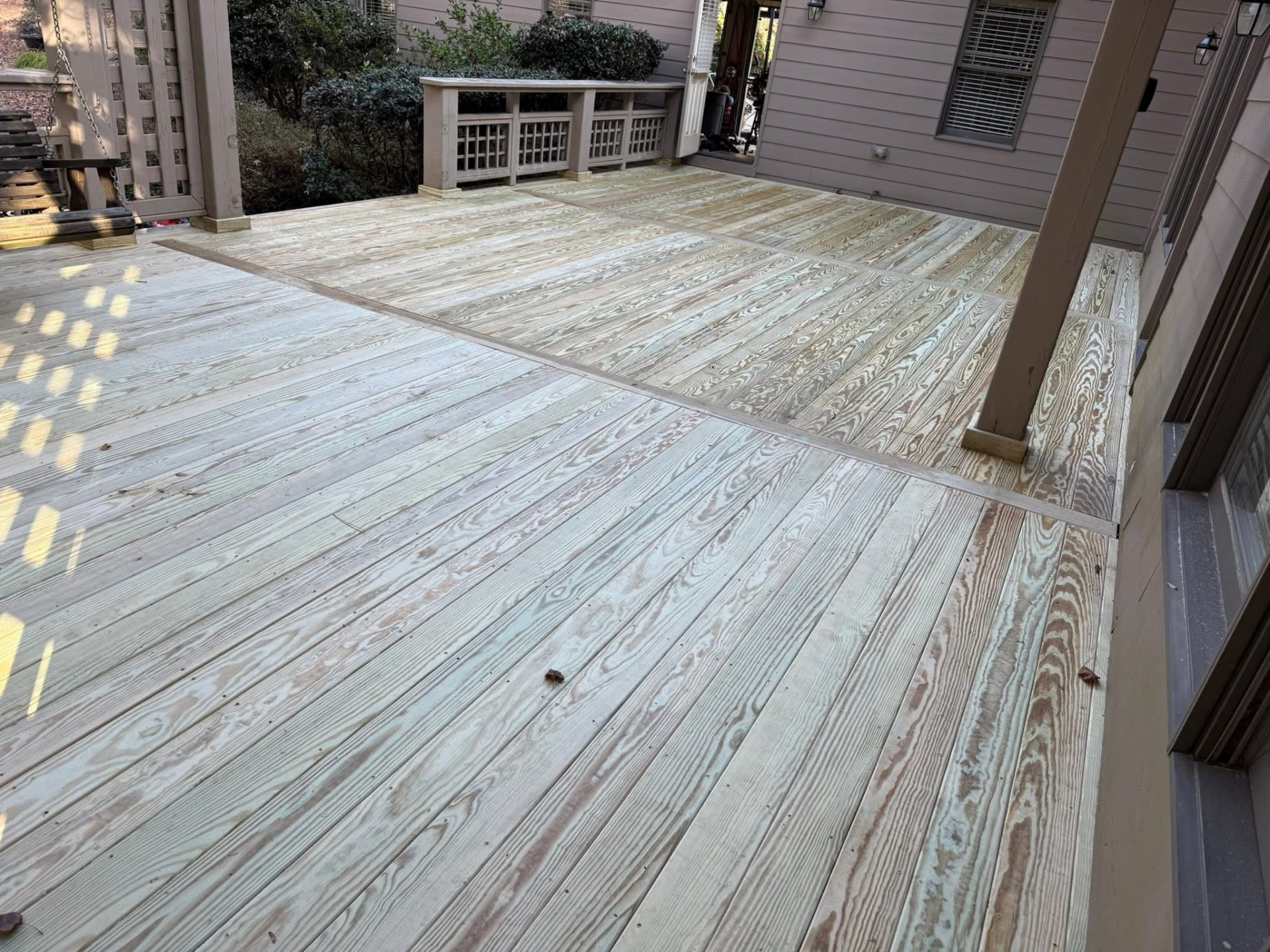 Large deck with fresh pressure-treated boards replacing worn decking