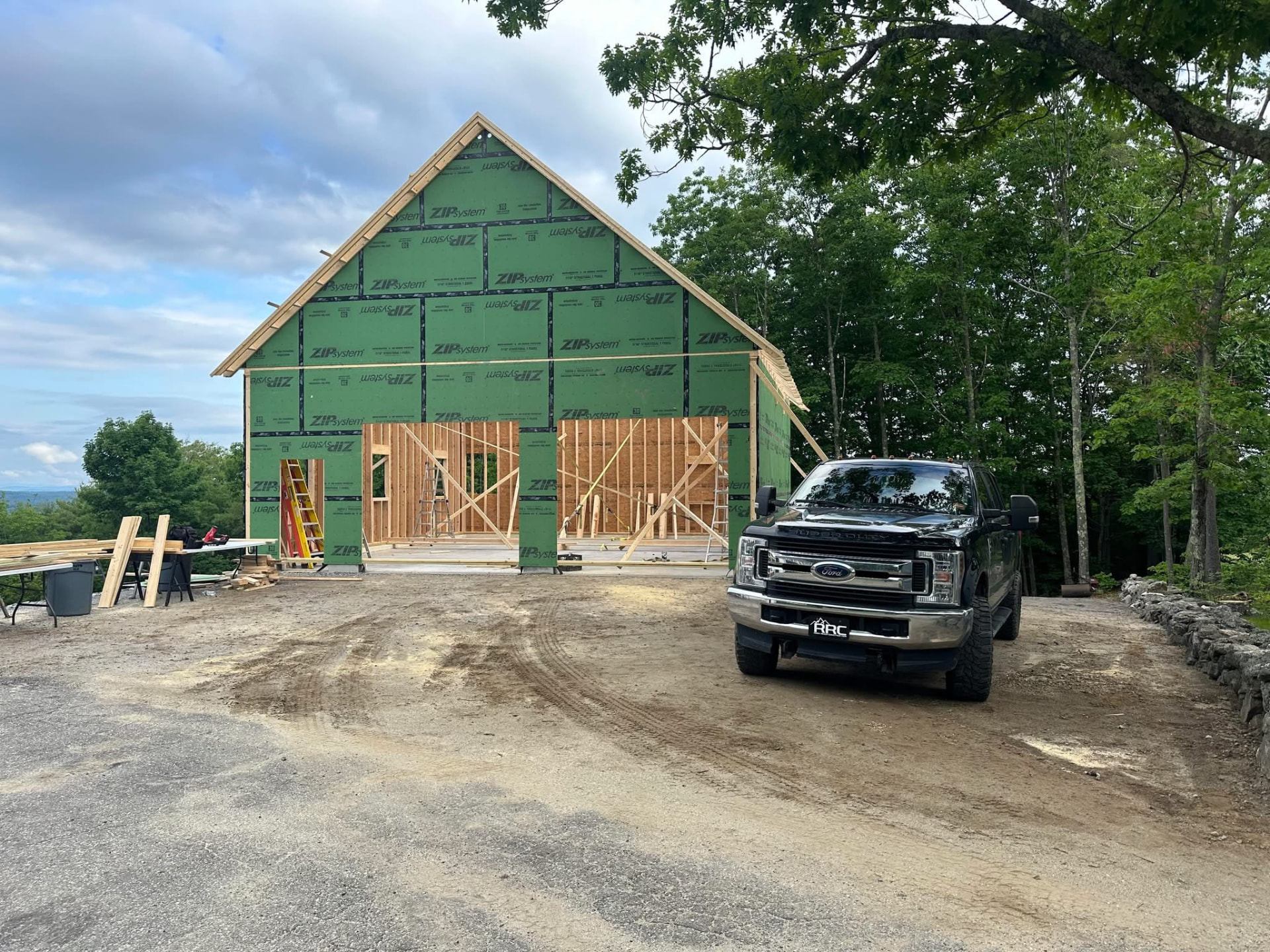 Garage addition framed and sheathed with the Rock River Construction truck on site